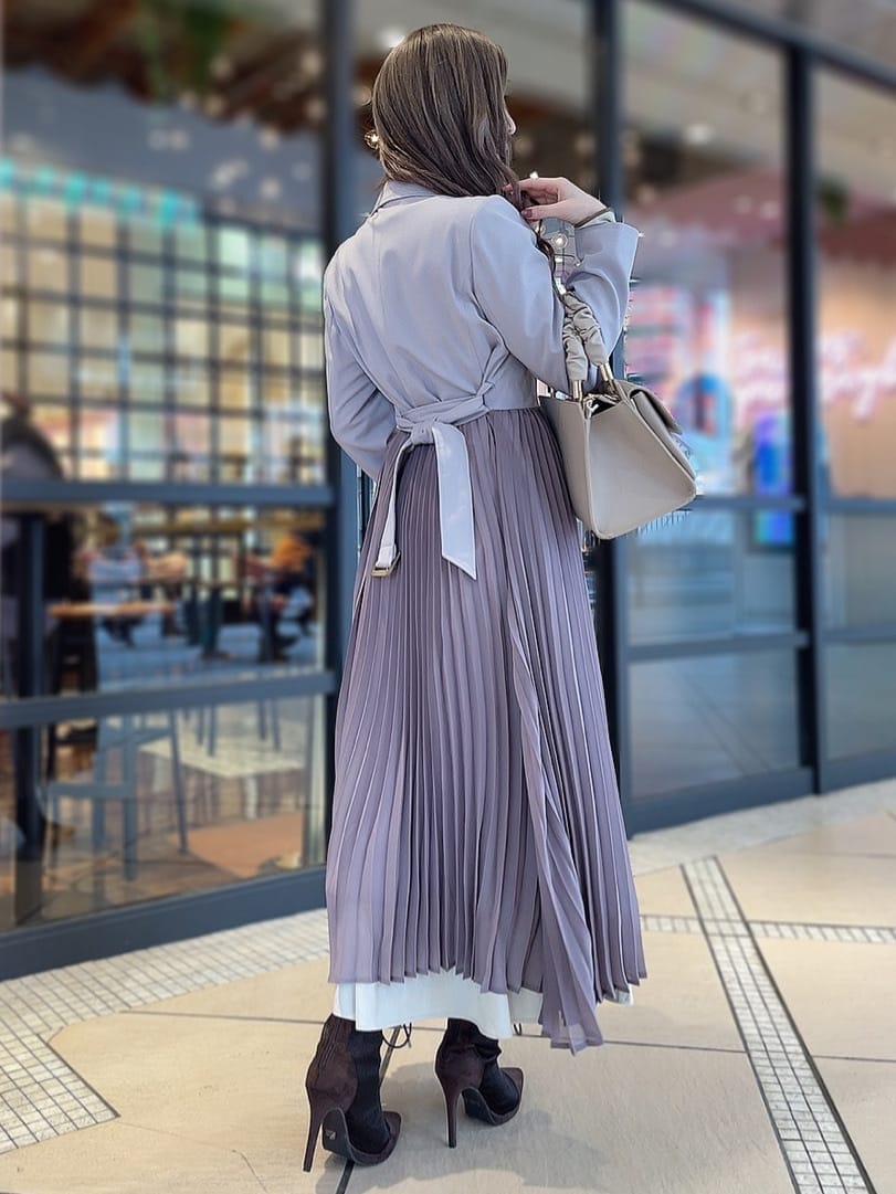 ベージュ系のワンピース、パープル系のトレンチコート、ブラウン系のブーツを着用したレディースの冬コーディネートの3枚目の写真