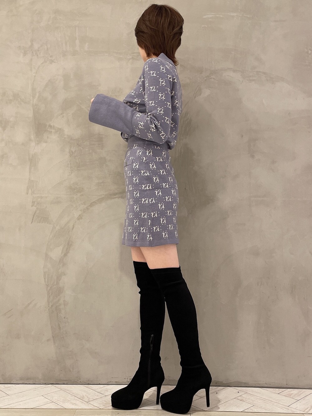 ブラック系のブーツ、ブルー系のニット/セーター、ブルー系のスカートを着用したレディースの冬コーディネートの3枚目の写真