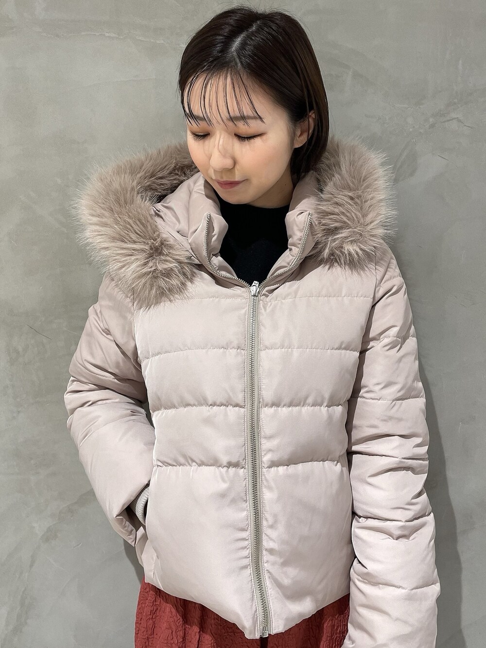 ベージュ系のダウンジャケット/コート、ブラック系のニット/セーター、ブラウン系のハンドバッグを着用したレディースの秋コーディネートの7枚目の写真