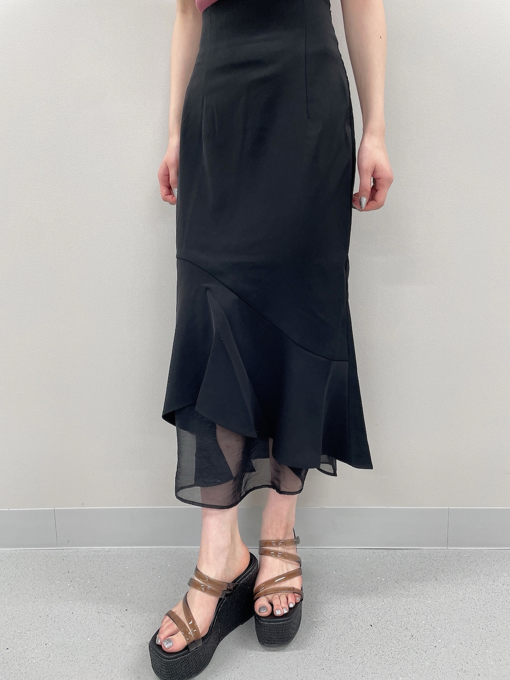 ピンク系のニット/セーター、ブラック系のスカート、ブラック系のサンダルを着用したレディースの春コーディネートの5枚目の写真