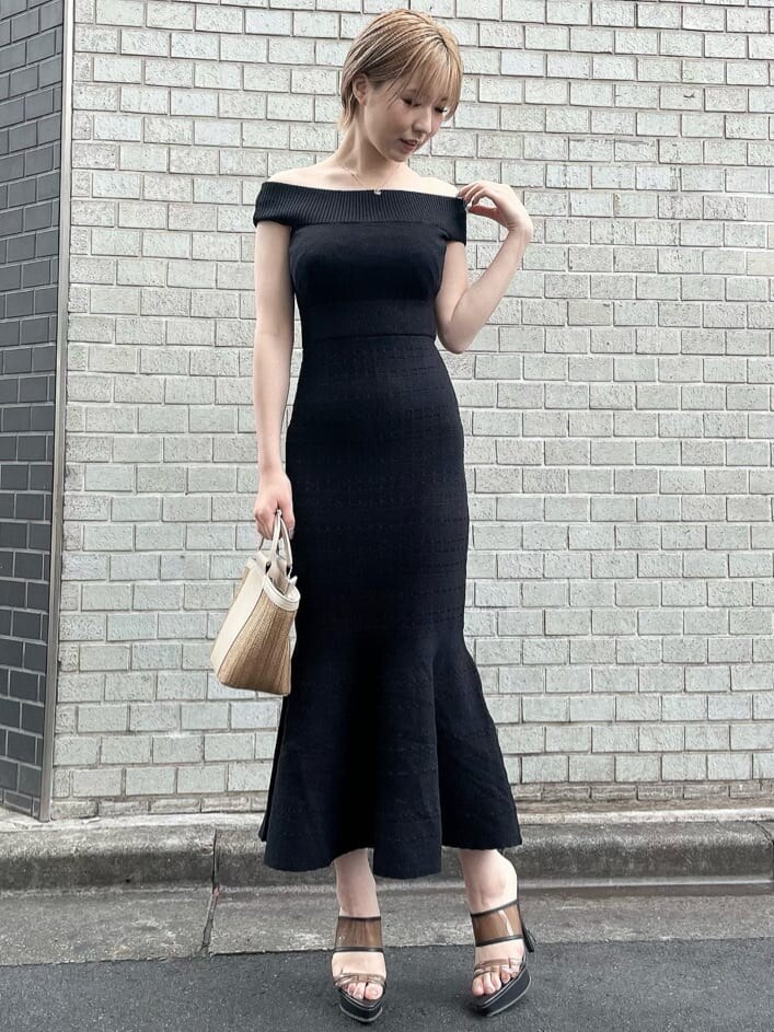 ブラック系のワンピース、ブラック系のサンダル、ベージュ系のハンドバッグを着用したレディースの夏コーディネートの4枚目の写真