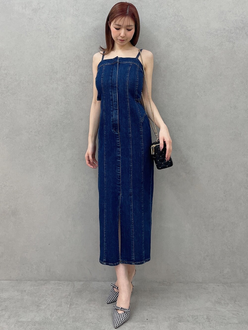 ブルー系のワンピース、ブラック系のショルダーバッグ、その他のパンプスを着用したレディースの冬コーディネートの2枚目の写真