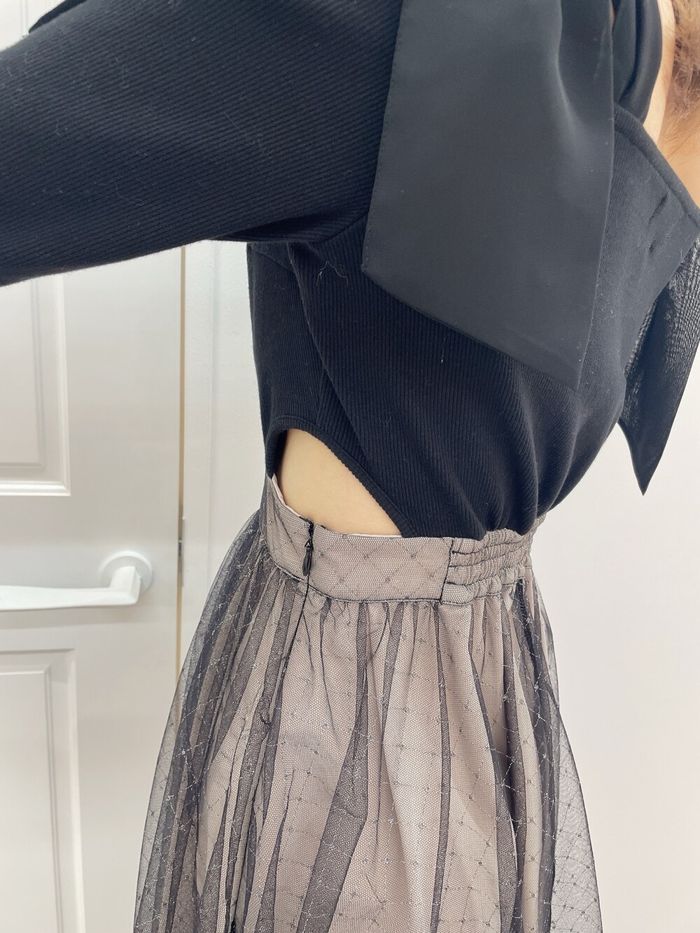 ブラック系のワンピース、ブラック系のハンドバッグ、ブラック系のパンプスを着用したレディースの冬コーディネートの7枚目の写真