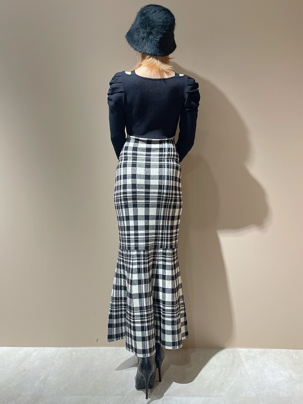 ブラック系のワンピース、ブラック系のブーツ、ブラック系のハットを着用したレディースの秋コーディネートの3枚目の写真