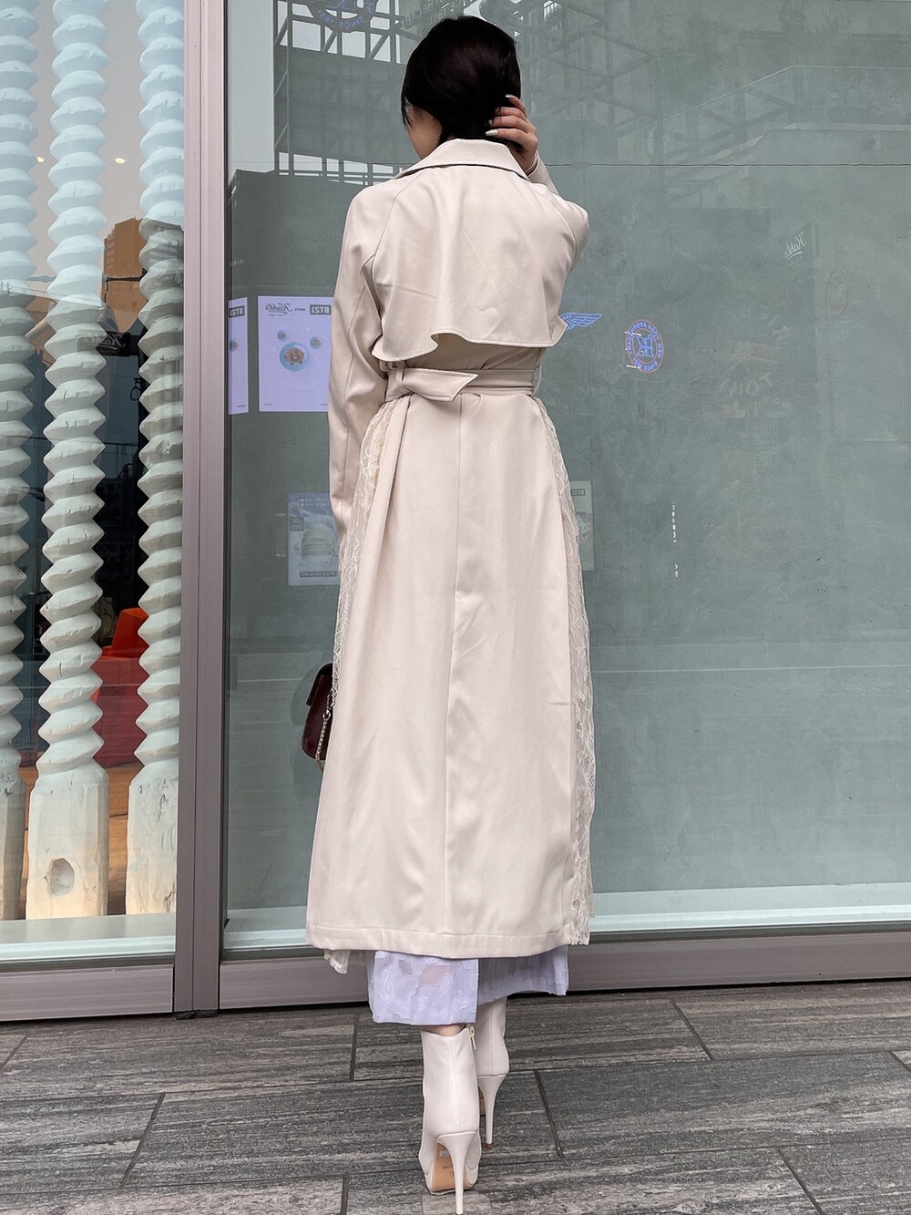 ブラウン系のハンドバッグ、ホワイト系のトレンチコート、ホワイト系のブーツを着用したレディースの冬コーディネートの4枚目の写真