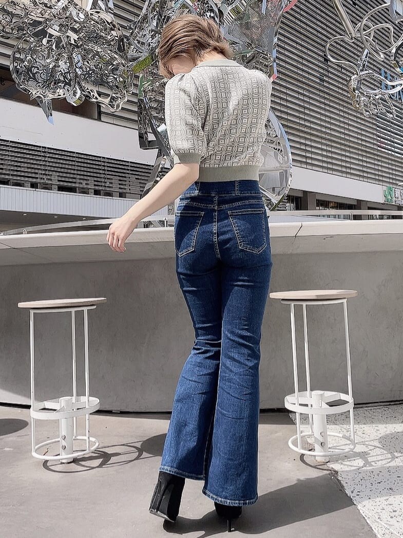 ブルー系のデニムパンツ、ブラック系のブーツ、グリーン系のニット/セーターを着用したレディースの春コーディネートの3枚目の写真