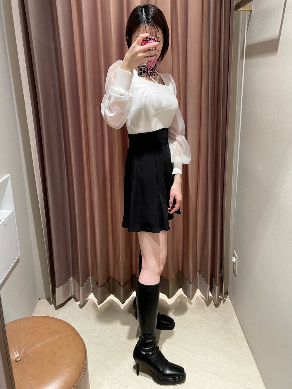 ホワイト系のニット/セーター、ブラック系のスカート、ブラック系のブーツを着用したレディースの冬コーディネートの4枚目の写真