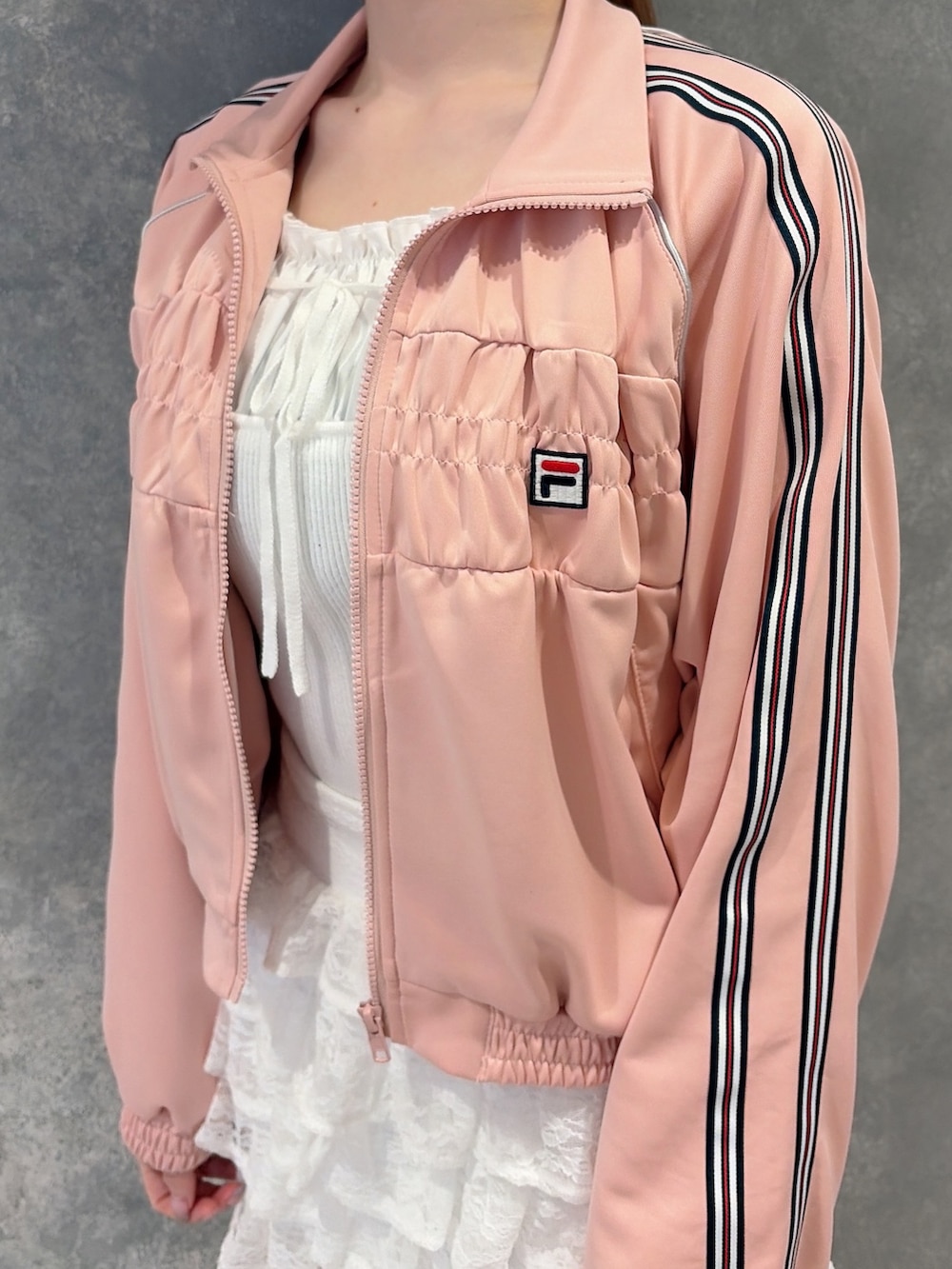 ピンク系のその他アウター、ホワイト系のスカート、ホワイト系のニット/セーターを着用したレディースの冬コーディネートの5枚目の写真