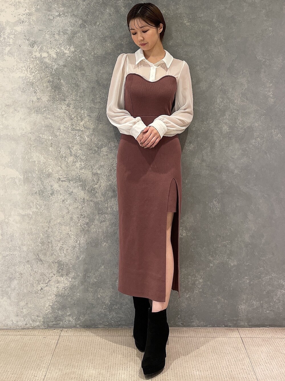 ブラック系のブーツ、ホワイト系のブルゾン、ブラウン系のワンピースを着用したレディースの秋コーディネートの4枚目の写真