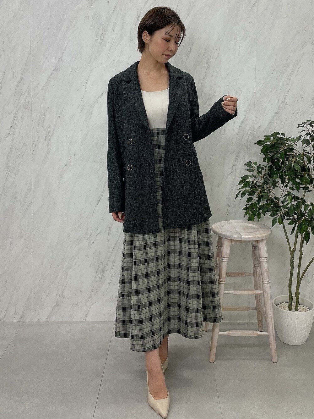 ベージュ系のサンダル、グレー系のテーラードジャケット、ホワイト系のワンピースを着用したレディースの秋コーディネートの2枚目の写真