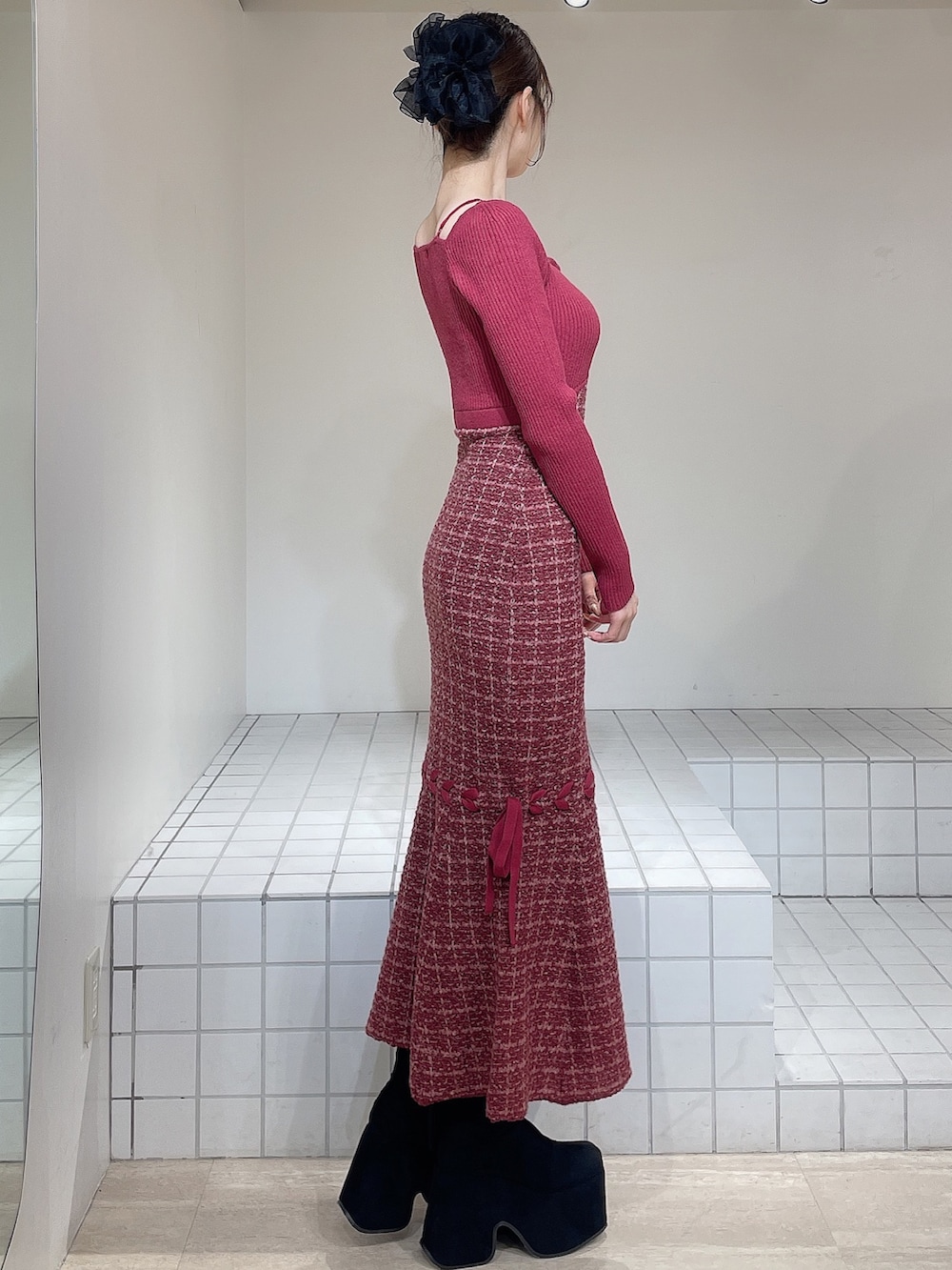 レッド系のワンピース、ブラック系のブーツ、ブラック系のバレッタ/ヘアクリップを着用したレディースの冬コーディネートの2枚目の写真