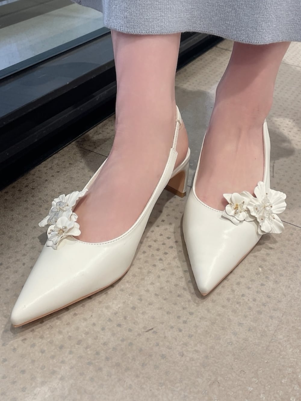 ホワイト系のライダースジャケット、ホワイト系のパンプス、グリーン系のワンピースを着用したレディースの冬コーディネートの9枚目の写真