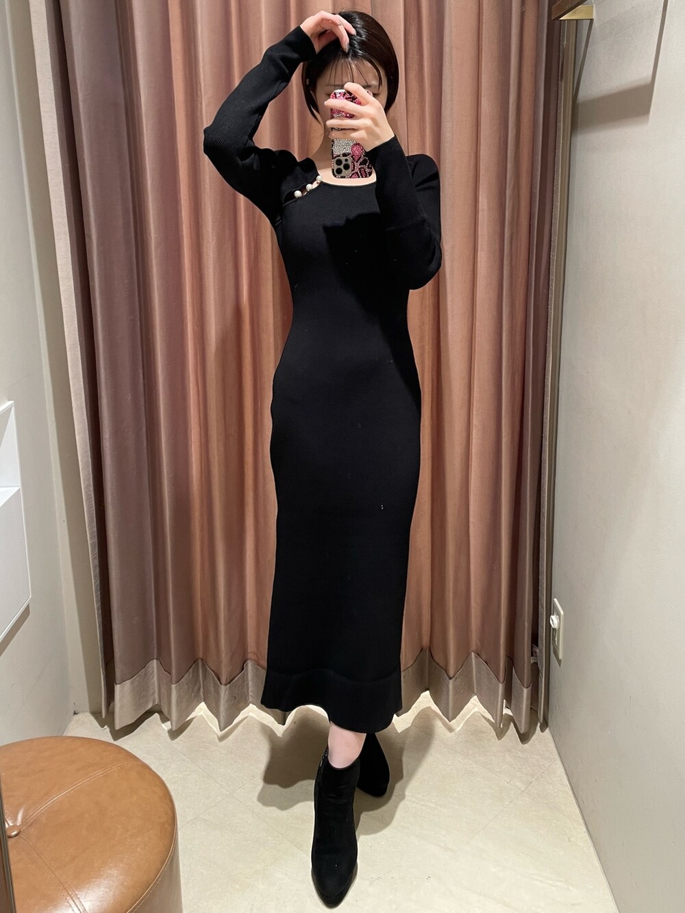 ブラック系のワンピース、ブラック系のブーツを着用したレディースの冬コーディネートの2枚目の写真