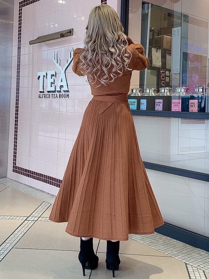 ブラック系のブーツ、オレンジ系のワンピースを着用したレディースの冬コーディネートの4枚目の写真