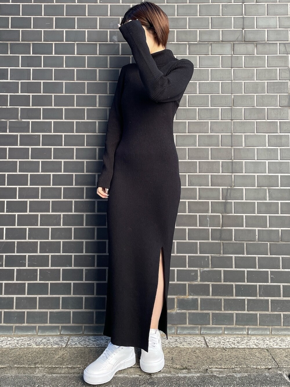 ブラック系のワンピース、ホワイト系のブルゾン、ホワイト系のスニーカーを着用したレディースの冬コーディネートの5枚目の写真