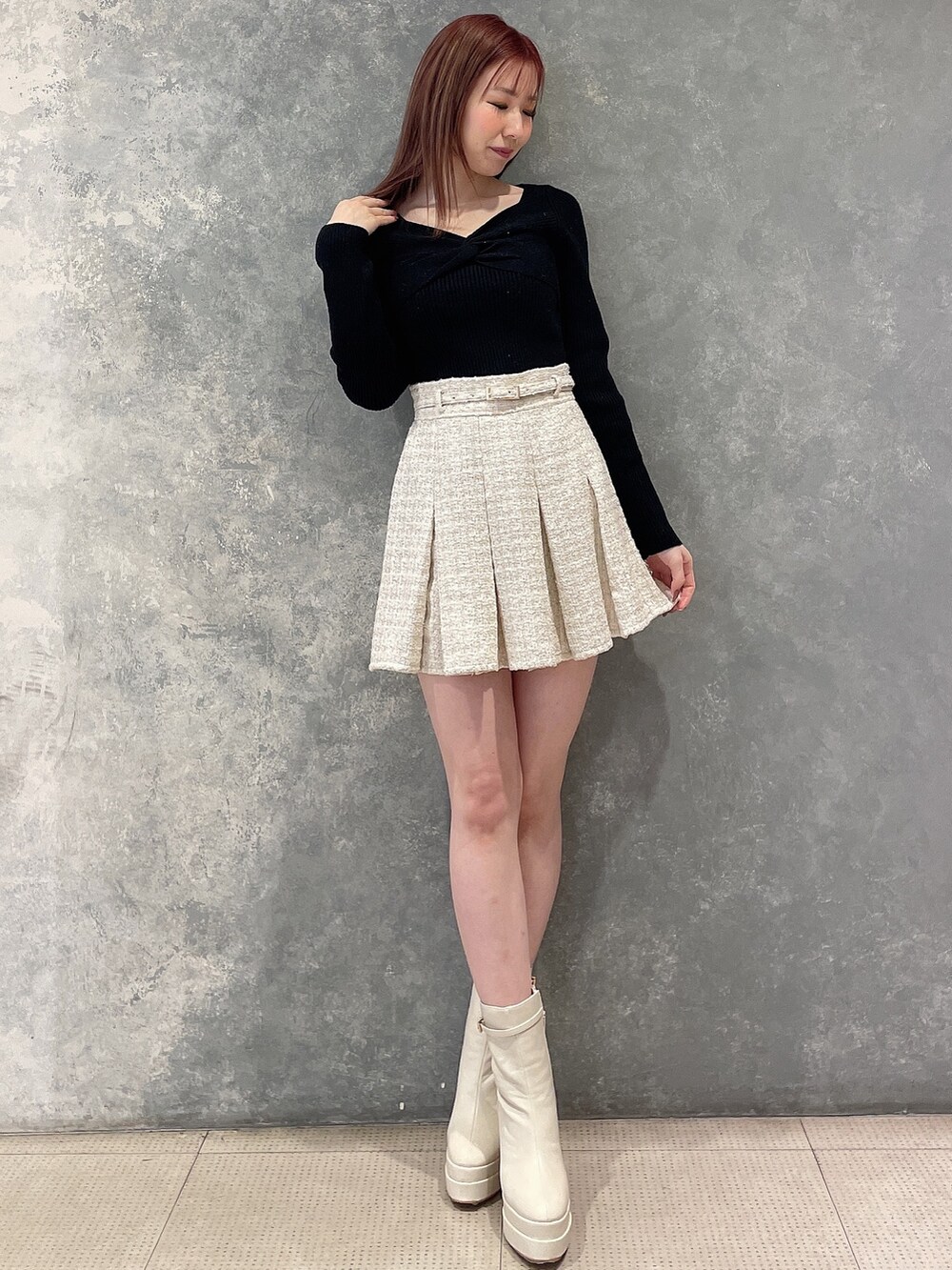 ホワイト系のテーラードジャケット、ホワイト系のスカート、ブラック系のニット/セーターを着用したレディースの冬コーディネートの5枚目の写真