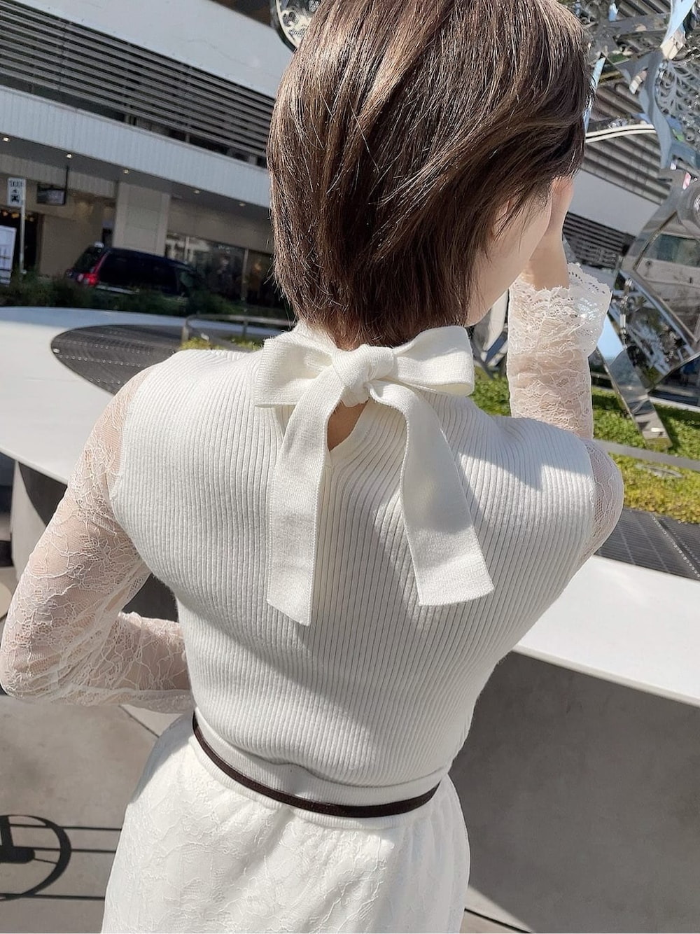 ホワイト系のスカート、ホワイト系のパンプス、ホワイト系のニット/セーターを着用したレディースの春コーディネートの5枚目の写真