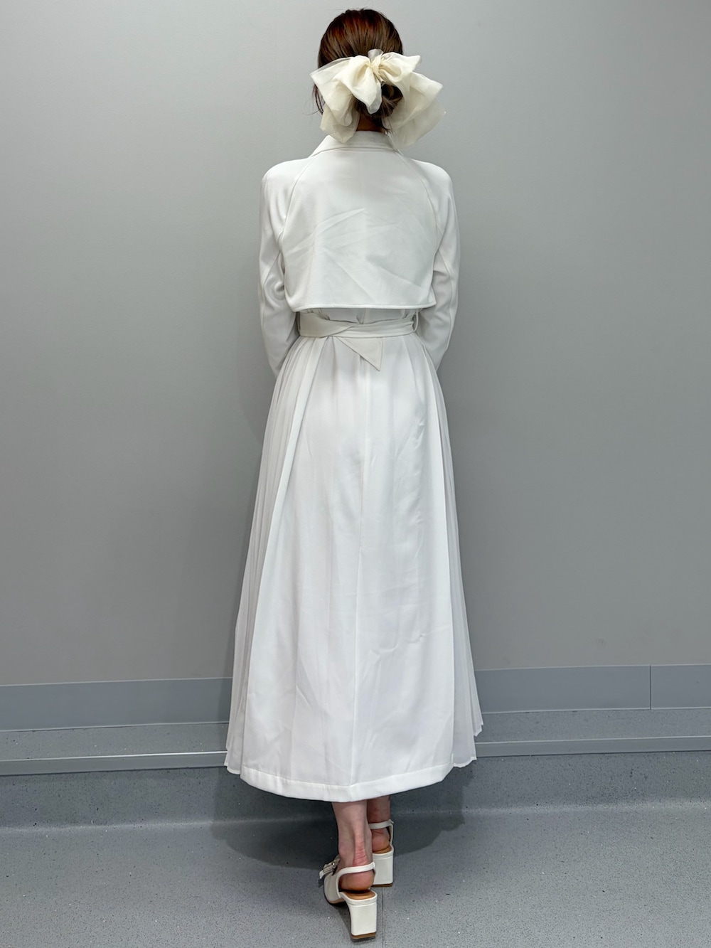 ホワイト系のトレンチコート、ピンク系のショルダーバッグ、オレンジ系のワンピースを着用したレディースの冬コーディネートの6枚目の写真