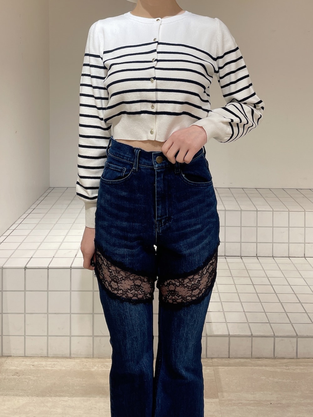 ホワイト系のカーディガン/ボレロ、ブルー系のデニムパンツ、ホワイト系のブーツを着用したレディースの春コーディネートの4枚目の写真