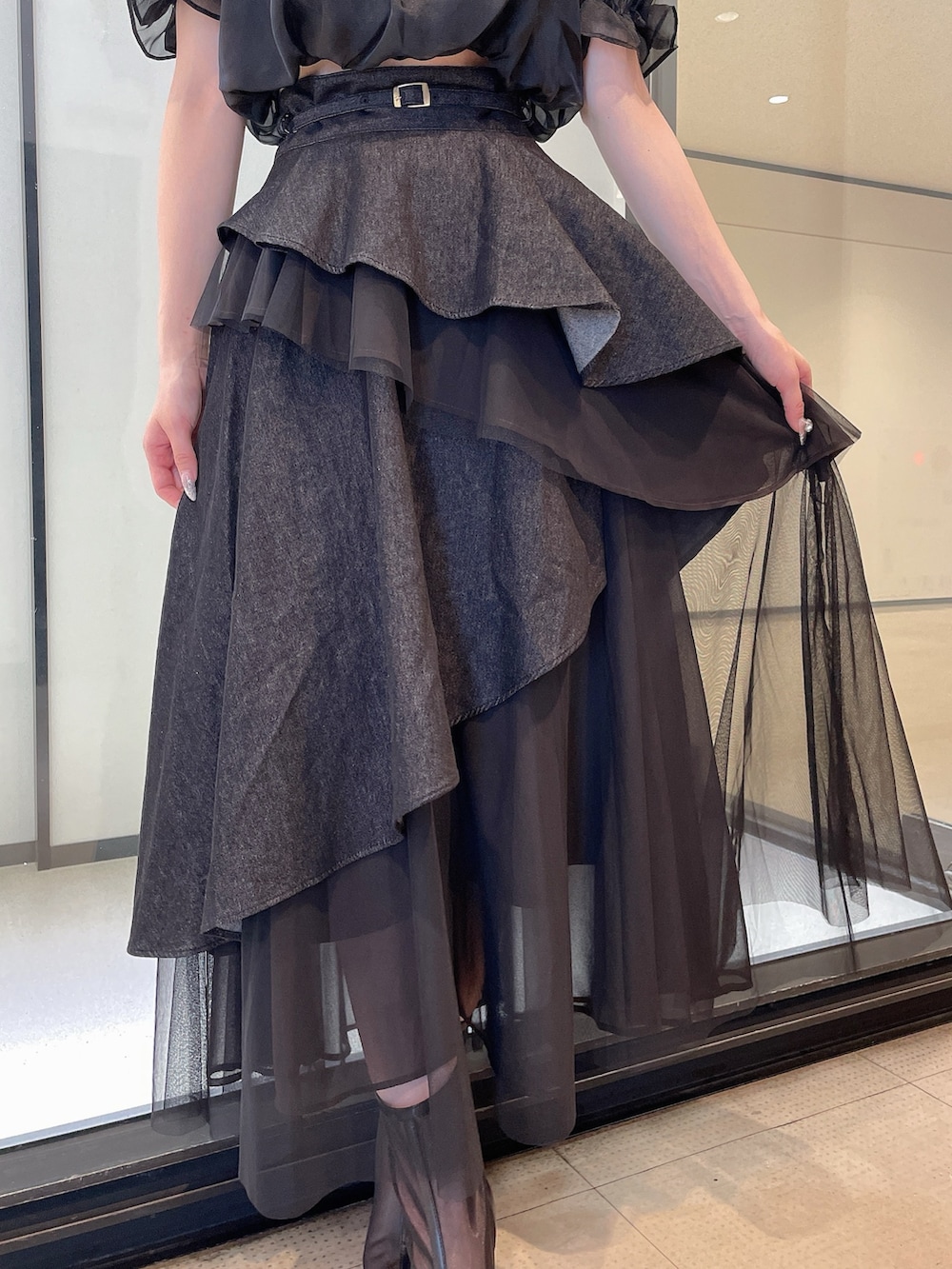 ブラック系のシャツ/ブラウス、ブラック系のデニムスカート、ブラック系のブーツを着用したレディースの夏コーディネートの7枚目の写真