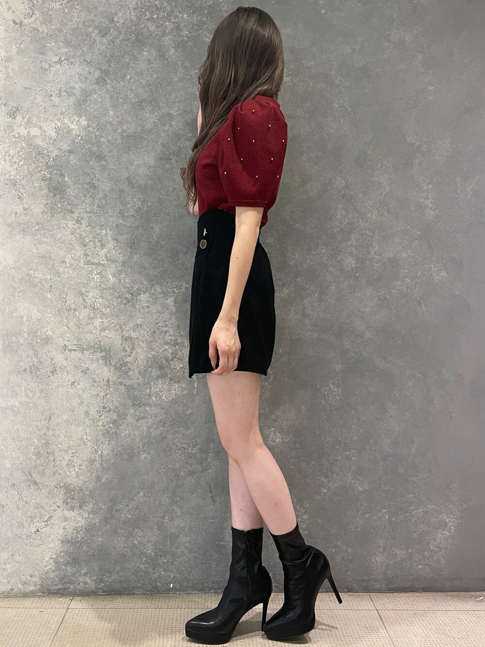 レッド系のTシャツ/カットソー、ブラック系のその他パンツ、ブラック系のブーツを着用したレディースの夏コーディネートの2枚目の写真