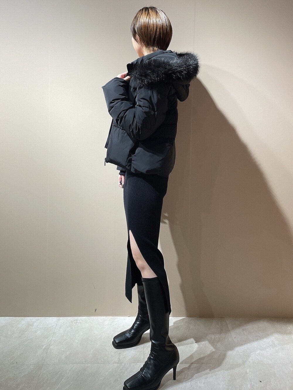 ブラック系のワンピース、ブラック系のダウンジャケット/コート、ブラック系のブーツを着用したレディースの秋コーディネートの5枚目の写真