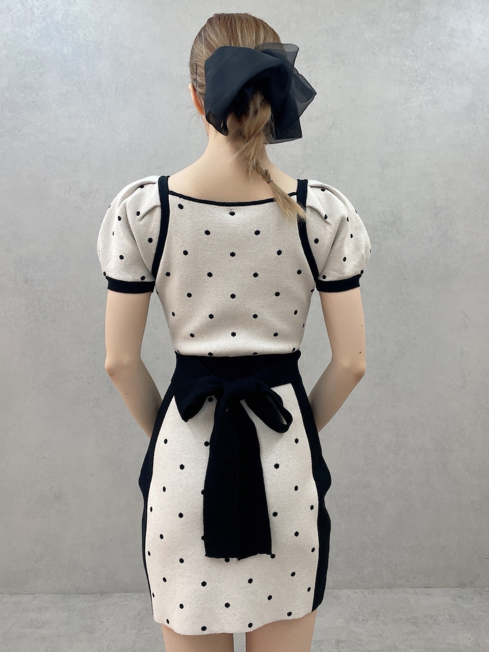 ブラック系のワンピース、ホワイト系のブーツ、ブラック系のバレッタ/ヘアクリップを着用したレディースの春コーディネートの6枚目の写真