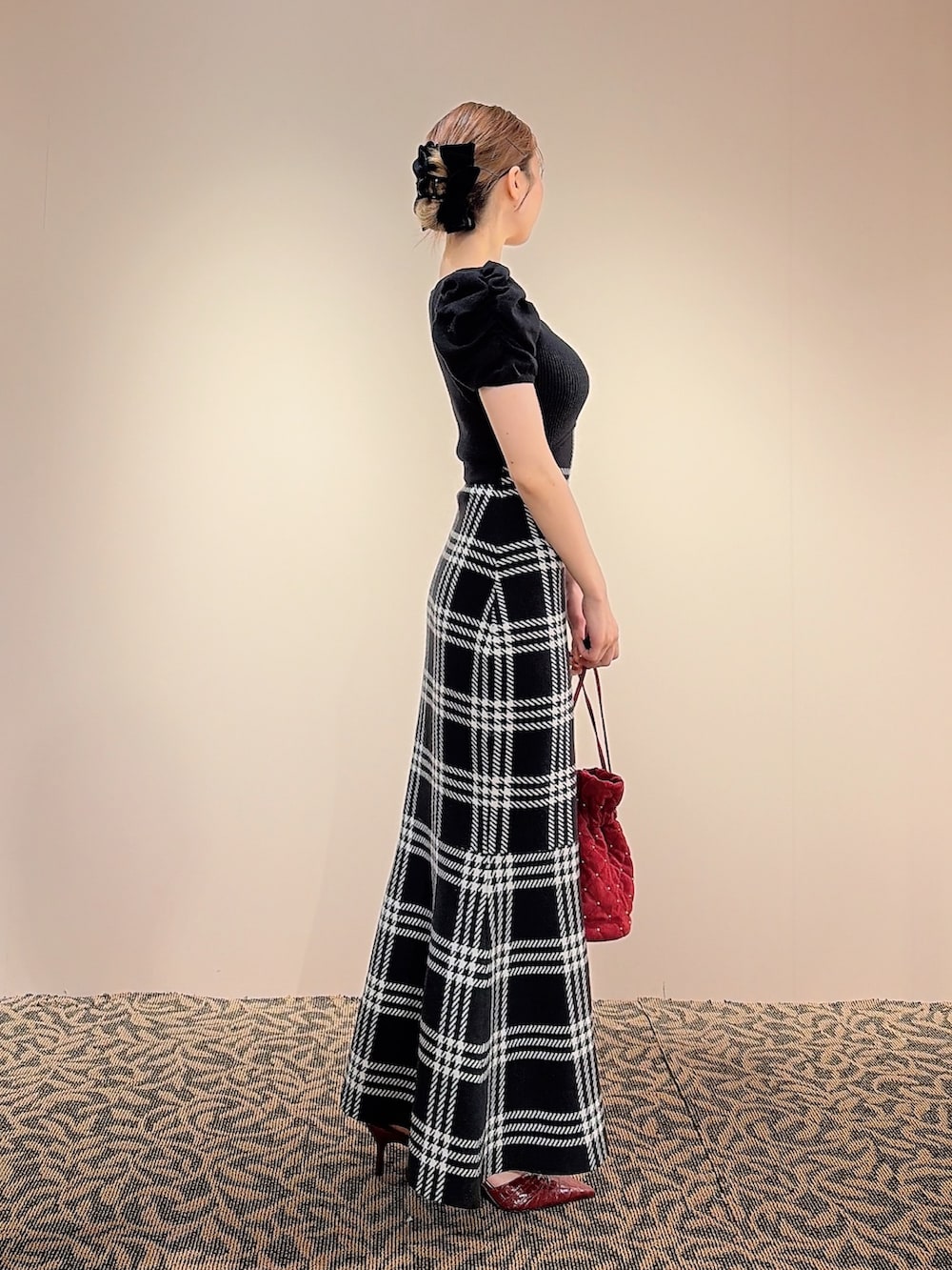 ブラック系のワンピース、レッド系のハンドバッグ、ブラック系のバレッタ/ヘアクリップを着用したレディースの夏コーディネートの3枚目の写真