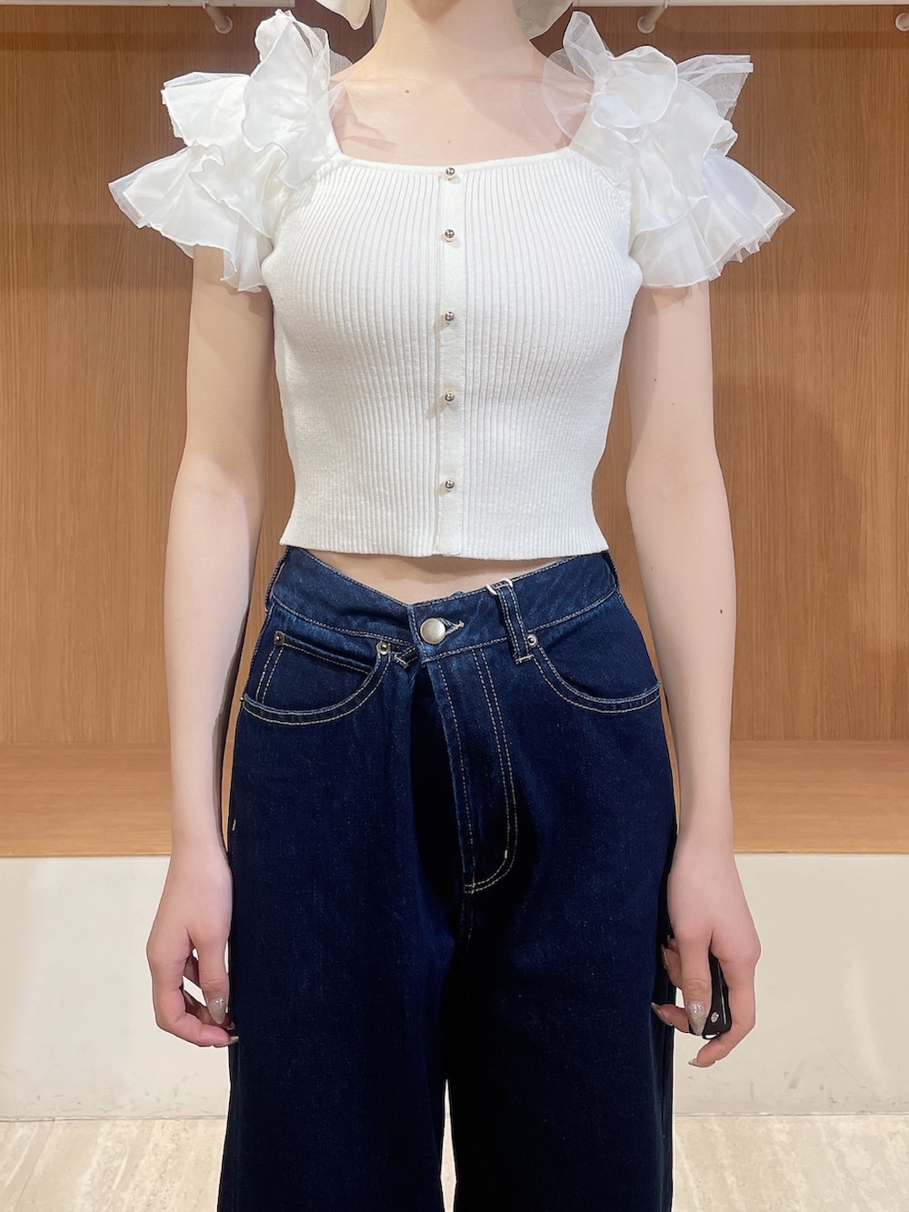 ホワイト系のニット/セーター、ブルー系のデニムパンツ、ホワイト系のサンダルを着用したレディースの春コーディネートの5枚目の写真