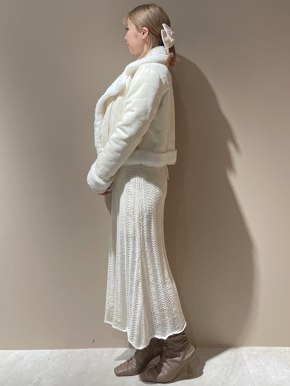 ホワイト系のブルゾン、ホワイト系のワンピース、ベージュ系のブーツを着用したレディースの秋コーディネートの2枚目の写真