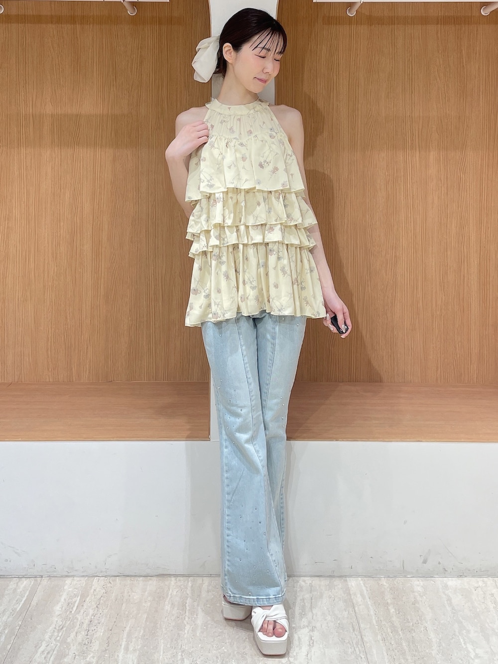 イエロー系のその他トップス、ブルー系のデニムパンツ、ホワイト系のサンダルを着用したレディースの春コーディネートの2枚目の写真