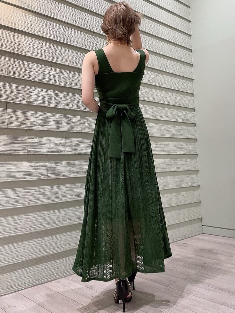 ブラック系のパンプス、ブラック系のショルダーバッグ、グリーン系のワンピースを着用したレディースの春コーディネートの3枚目の写真