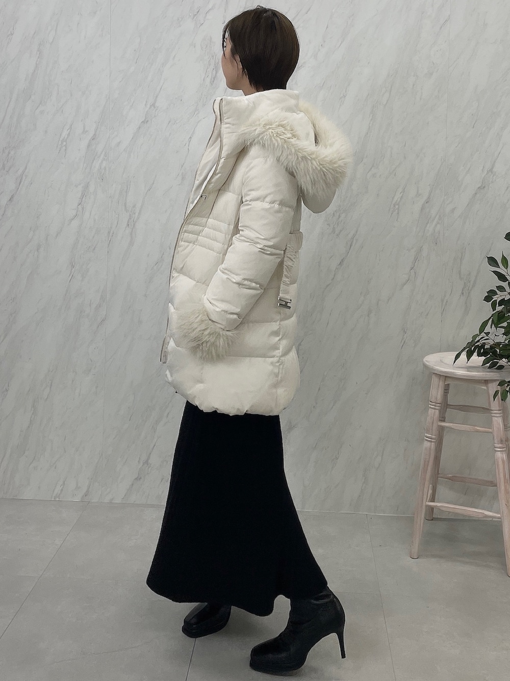 ブラック系のブーツ、ブラック系のワンピース、ホワイト系のダウンジャケット/コートを着用したレディースの夏コーディネートの5枚目の写真