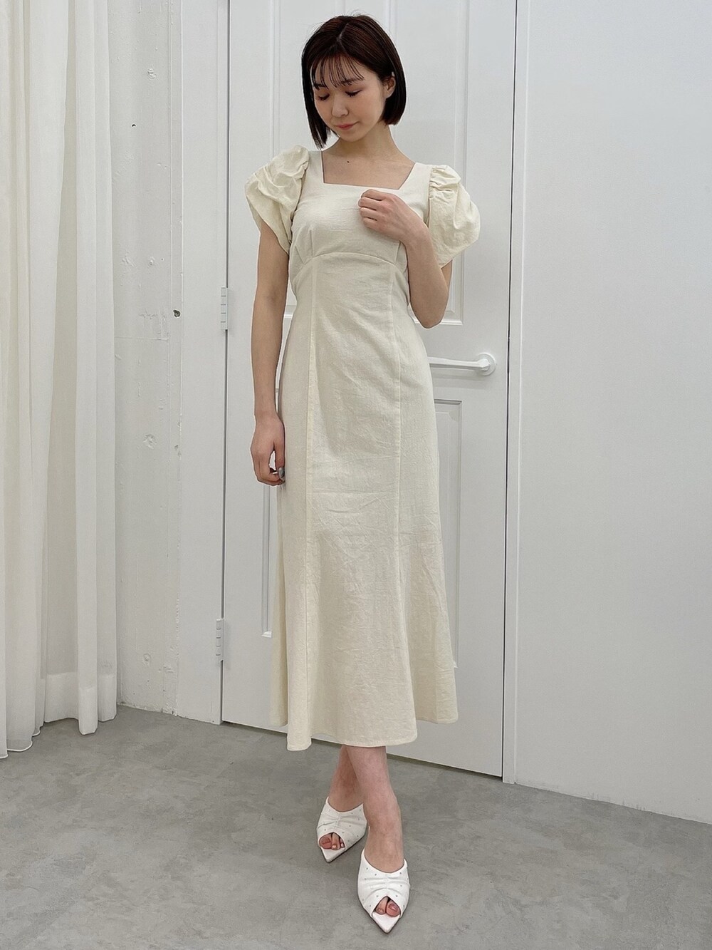 ホワイト系のワンピース、ホワイト系のサンダルを着用したレディースの春コーディネートの3枚目の写真