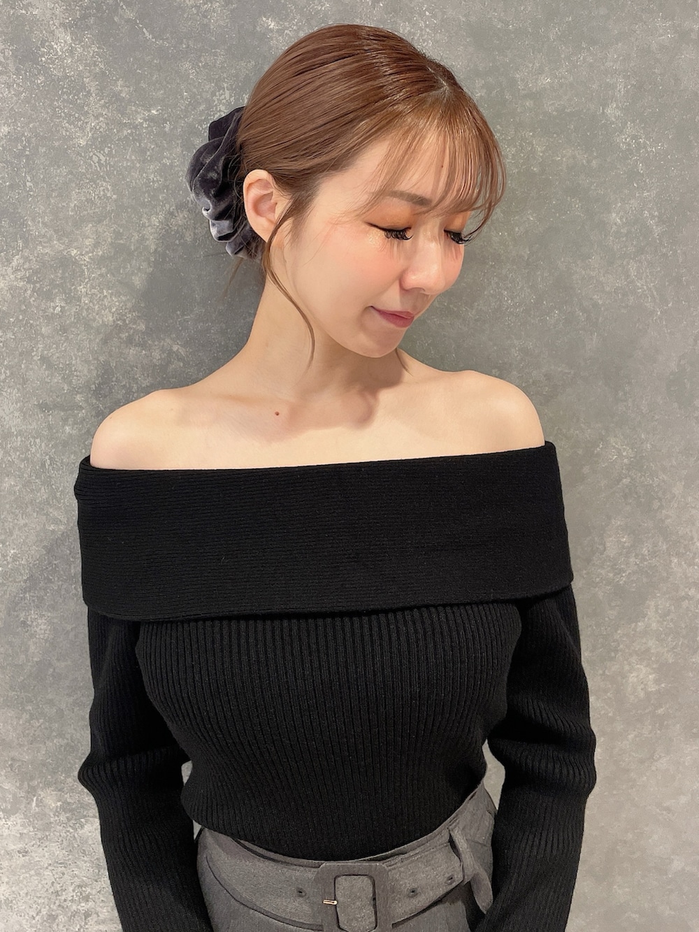 ブラック系のニット/セーター、グレー系のスカート、ブラック系のブーツを着用したレディースの秋コーディネートの4枚目の写真
