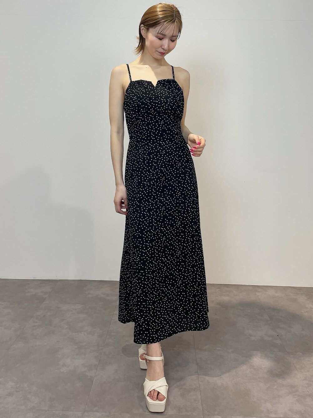 ブラック系のワンピース、ホワイト系のサンダルを着用したレディースの冬コーディネートの3枚目の写真