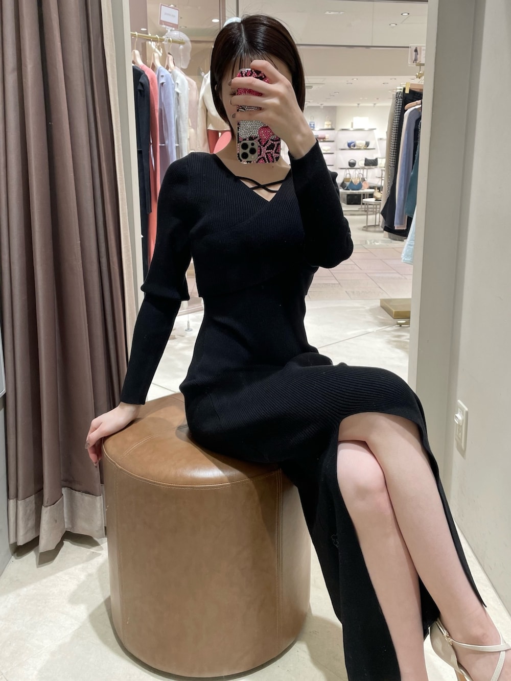 ブラック系のワンピース、ホワイト系のパンプスを着用したレディースの冬コーディネートの6枚目の写真