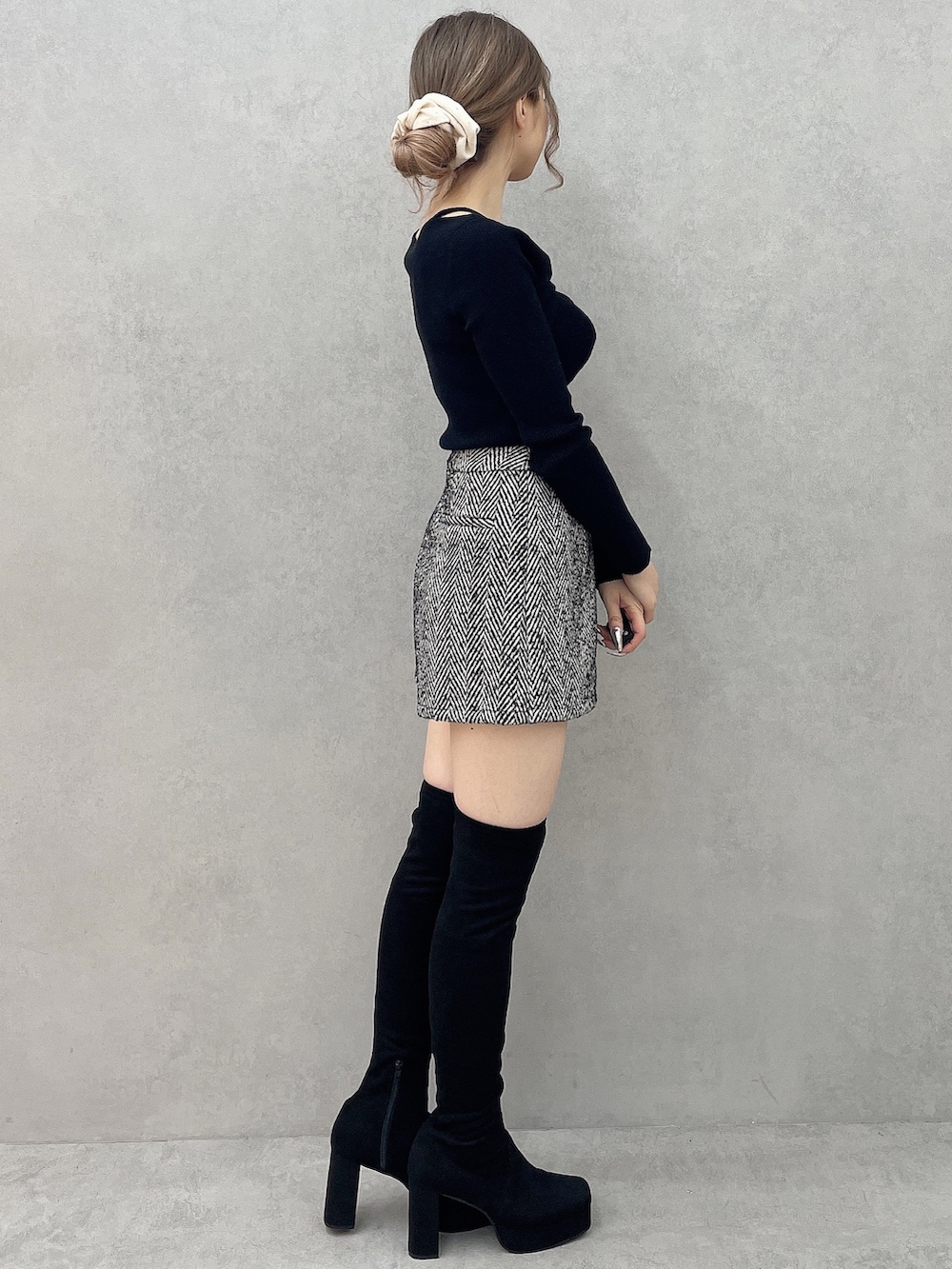 ブラック系のブーツ、ブラック系のニット/セーター、ブラック系のその他パンツを着用したレディースの秋コーディネートの6枚目の写真