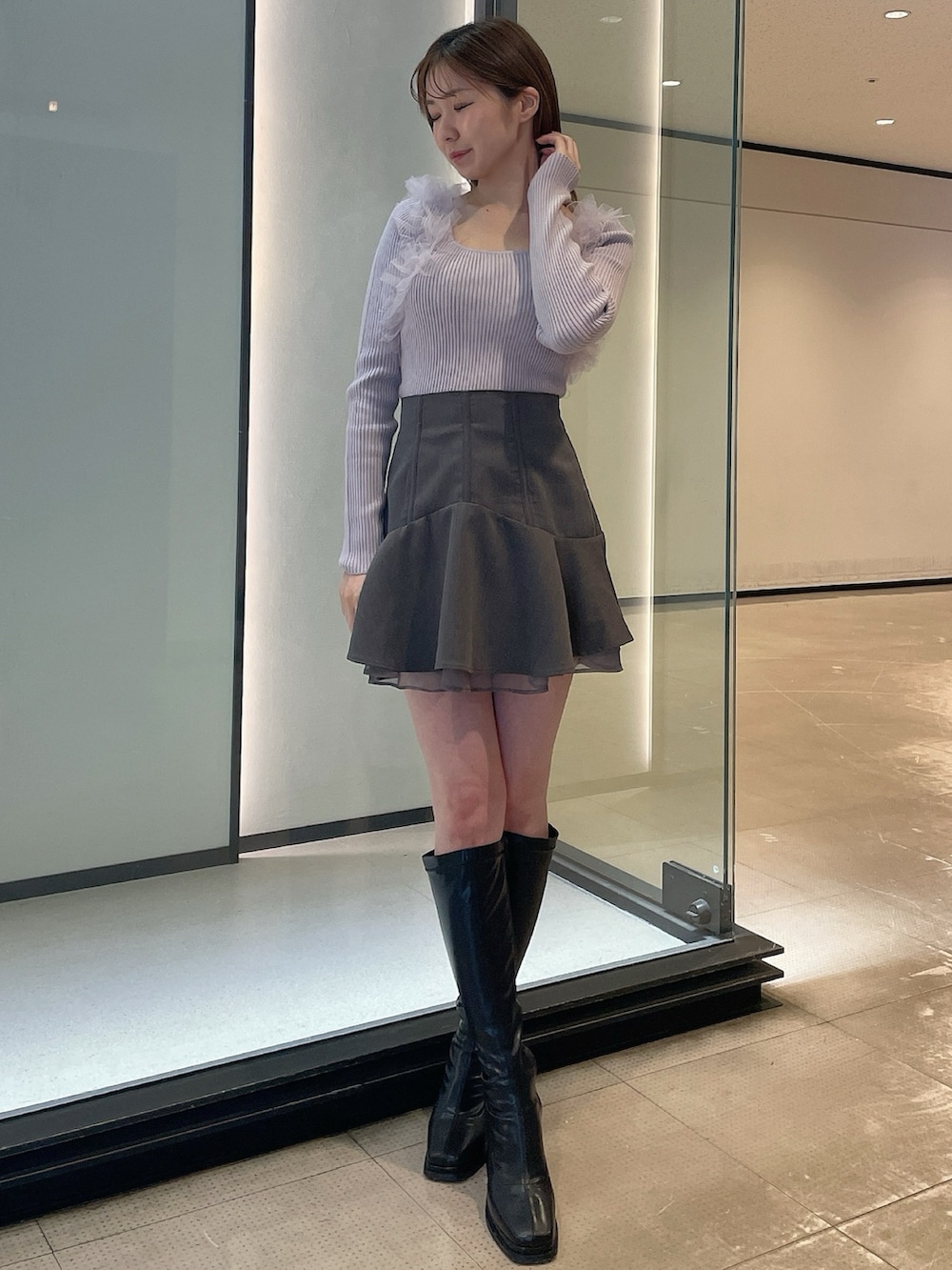 ブラック系のブーツ、グレー系のスカート、パープル系のニット/セーターを着用したレディースの冬コーディネートの2枚目の写真