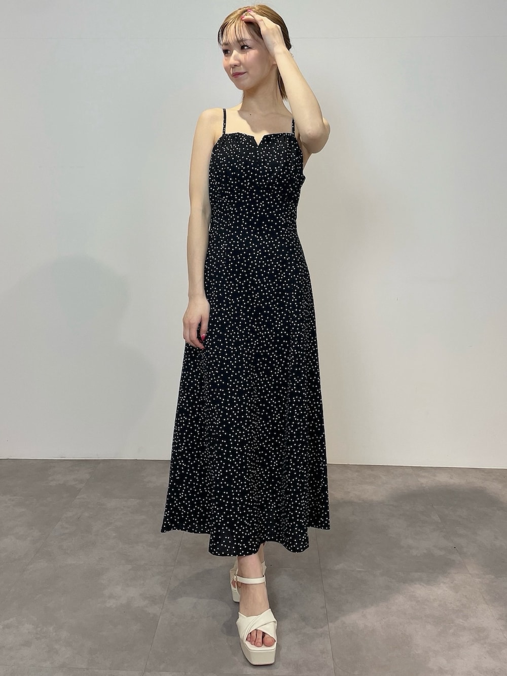 ブラック系のワンピース、ホワイト系のサンダルを着用したレディースの冬コーディネートの2枚目の写真