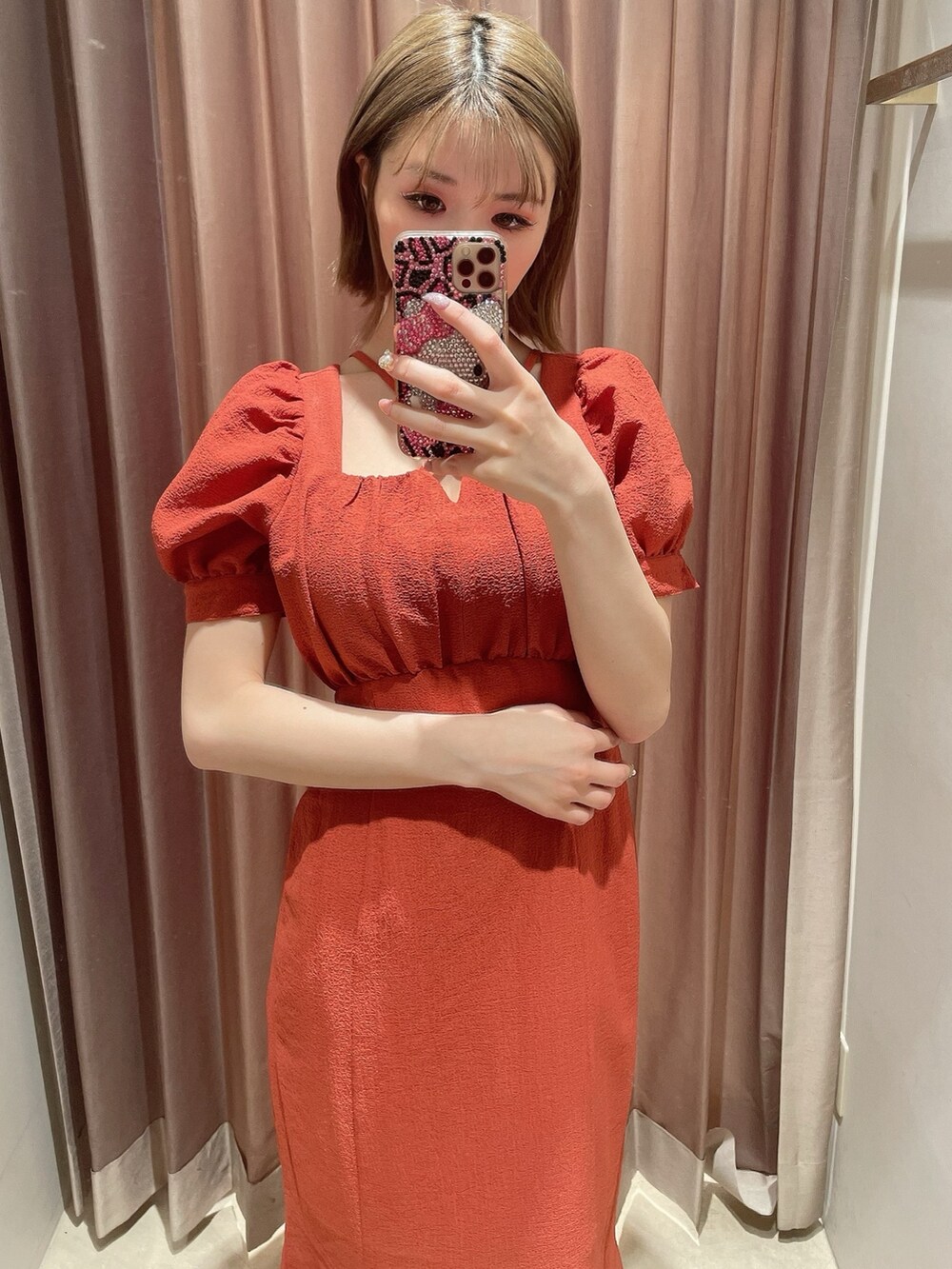 オレンジ系のワンピース、ホワイト系のサンダルを着用したレディースの春コーディネートの7枚目の写真