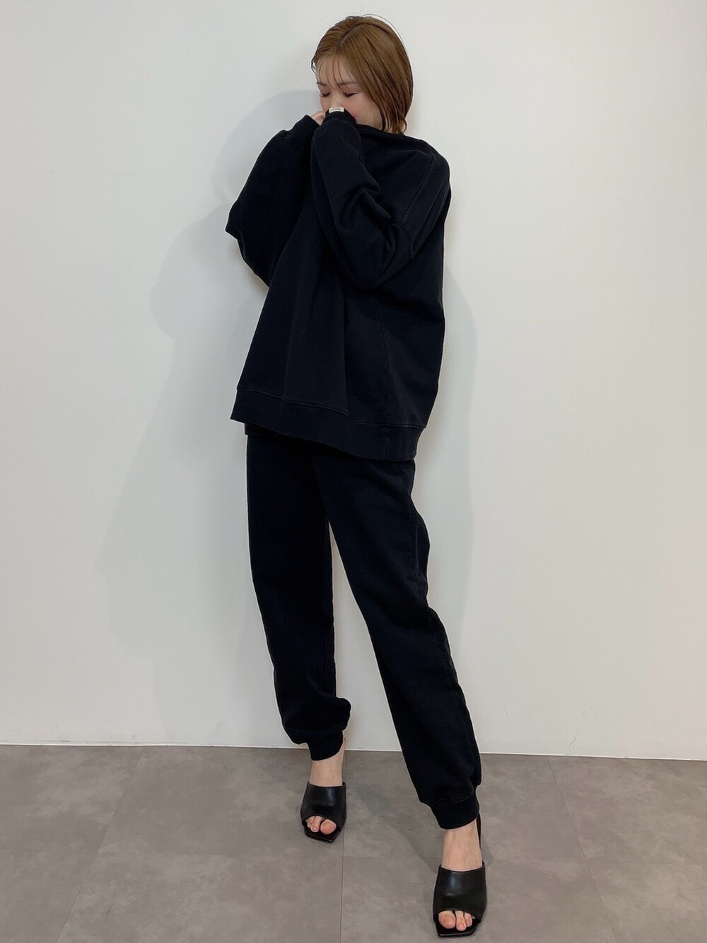 ブラック系のスウェット、ブラック系のスウェットパンツ、ブラック系のサンダルを着用したレディースの冬コーディネートの2枚目の写真