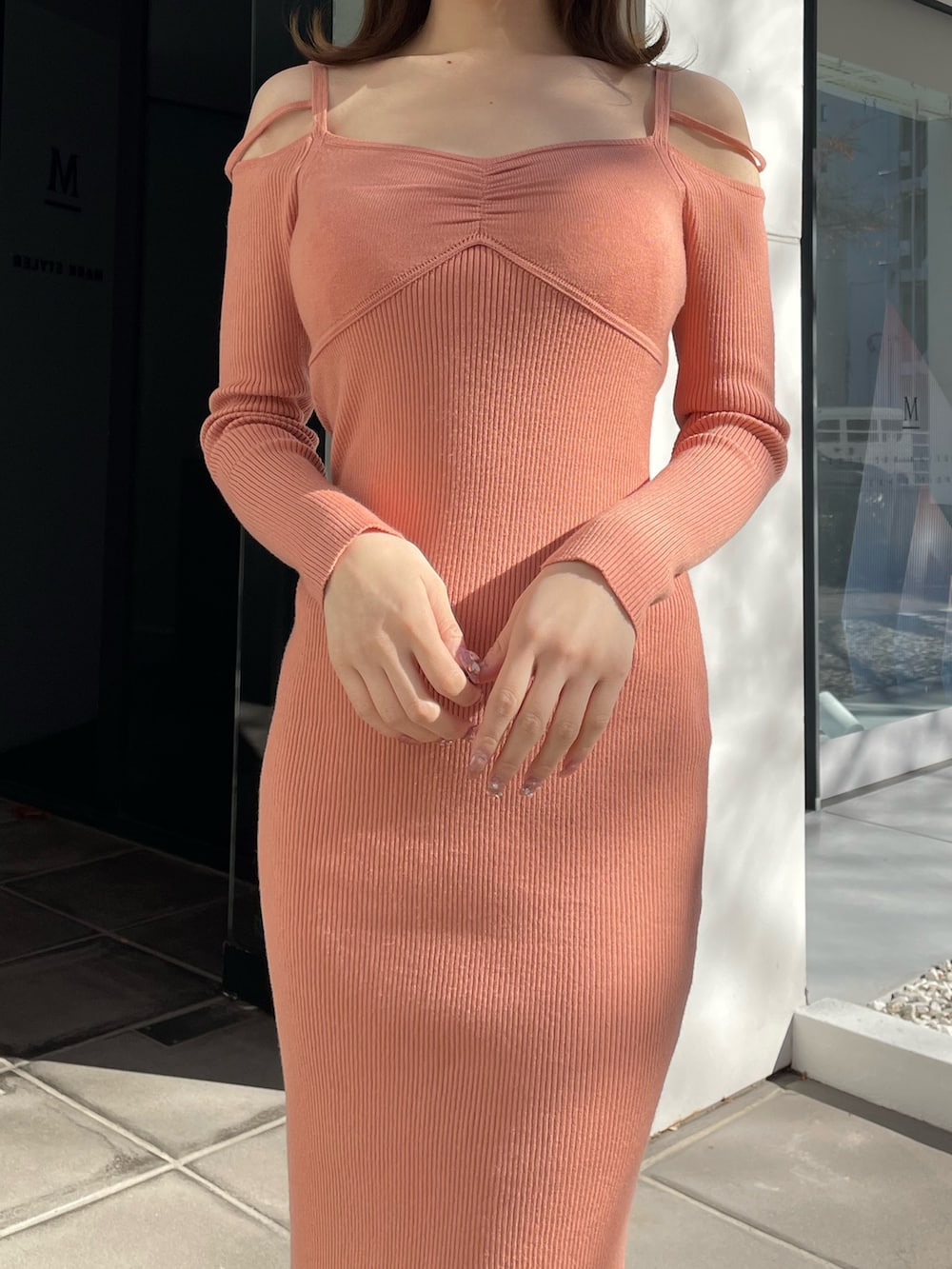 オレンジ系のワンピース、ホワイト系のパンプスを着用したレディースの冬コーディネートの4枚目の写真