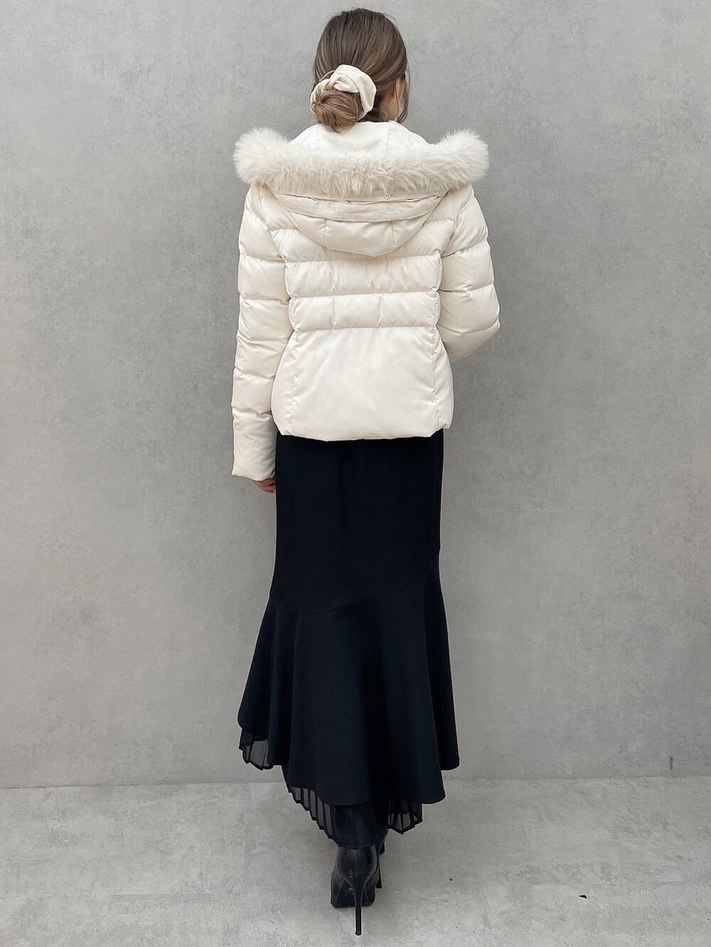ホワイト系のダウンジャケット/コート、ホワイト系のニット/セーター、ブラック系のスカートを着用したレディースの秋コーディネートの3枚目の写真
