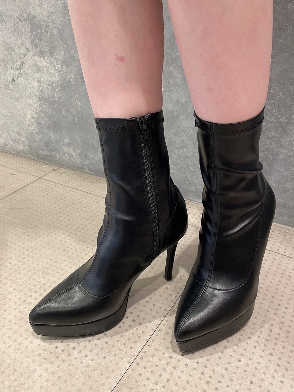 グレー系のワンピース、ブラック系のハンドバッグ、ブラック系のブーツを着用したレディースの秋コーディネートの9枚目の写真