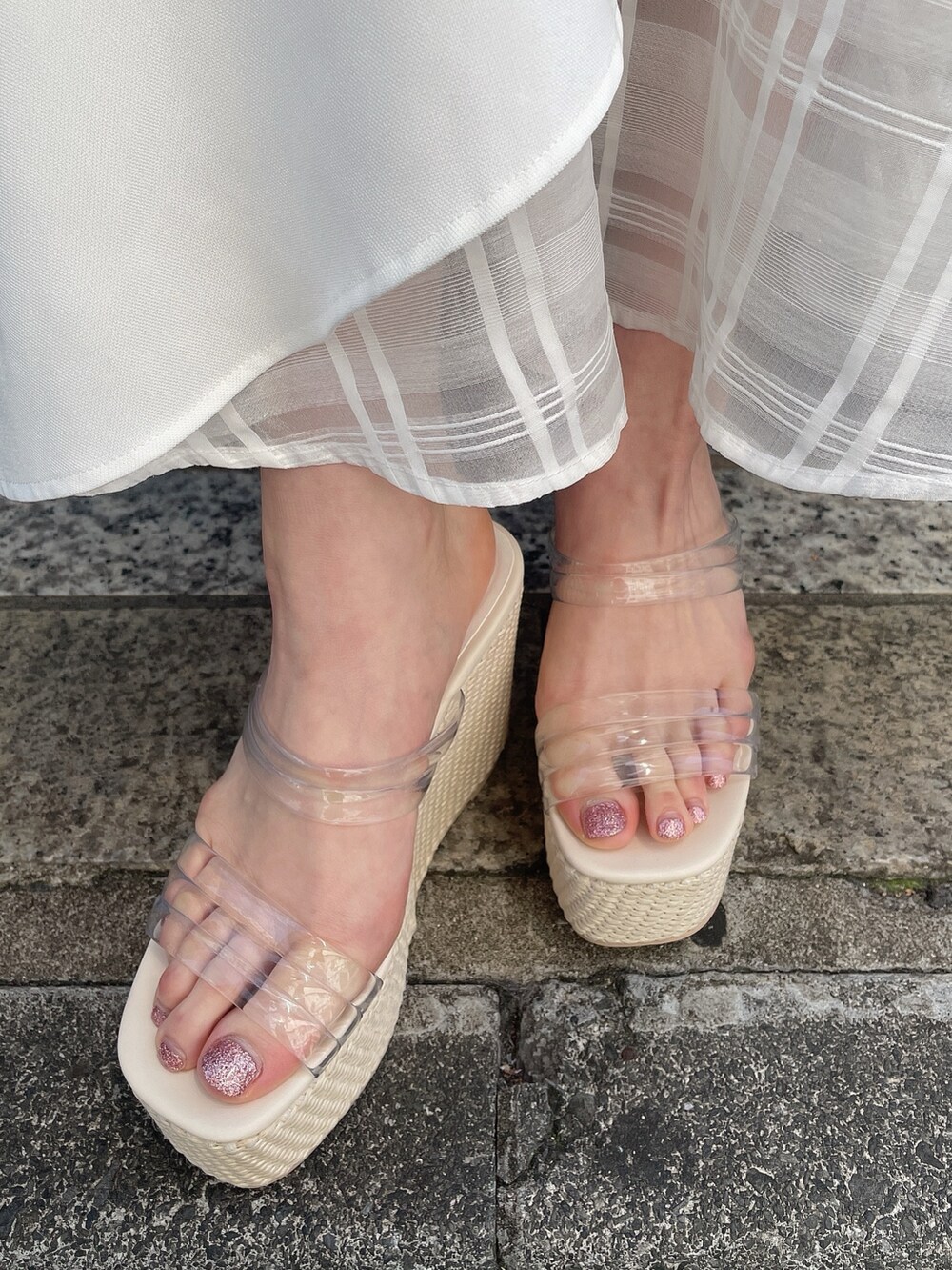 グリーン系のニット/セーター、ブルー系のスカート、ホワイト系のサンダルを着用したレディースの春コーディネートの7枚目の写真