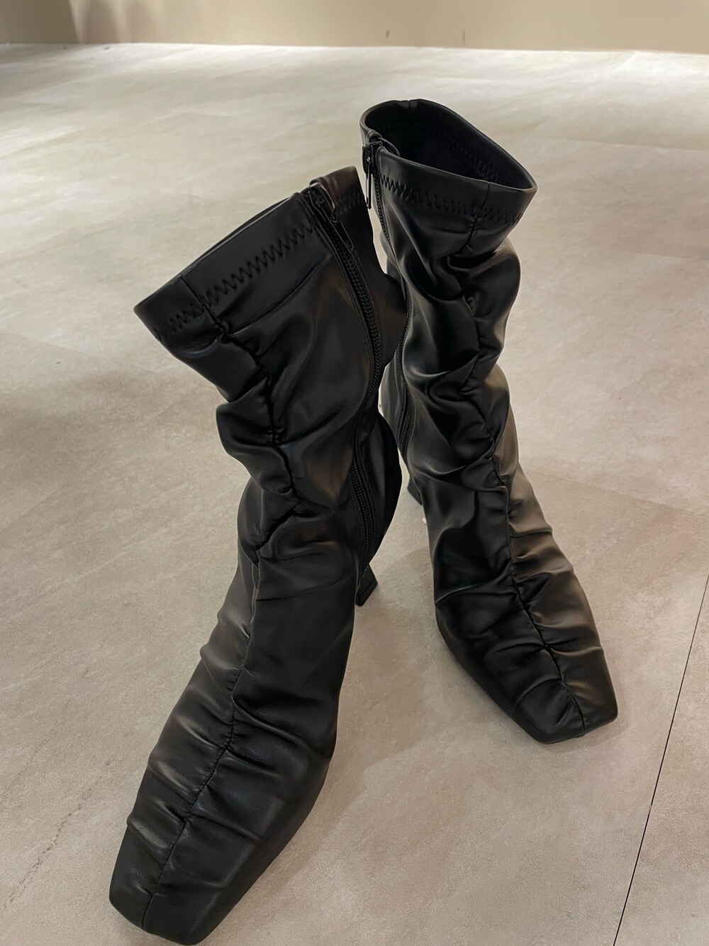 ブラック系のライダースジャケット、グレー系のワンピース、ブラック系のハンドバッグを着用したレディースの秋コーディネートの8枚目の写真