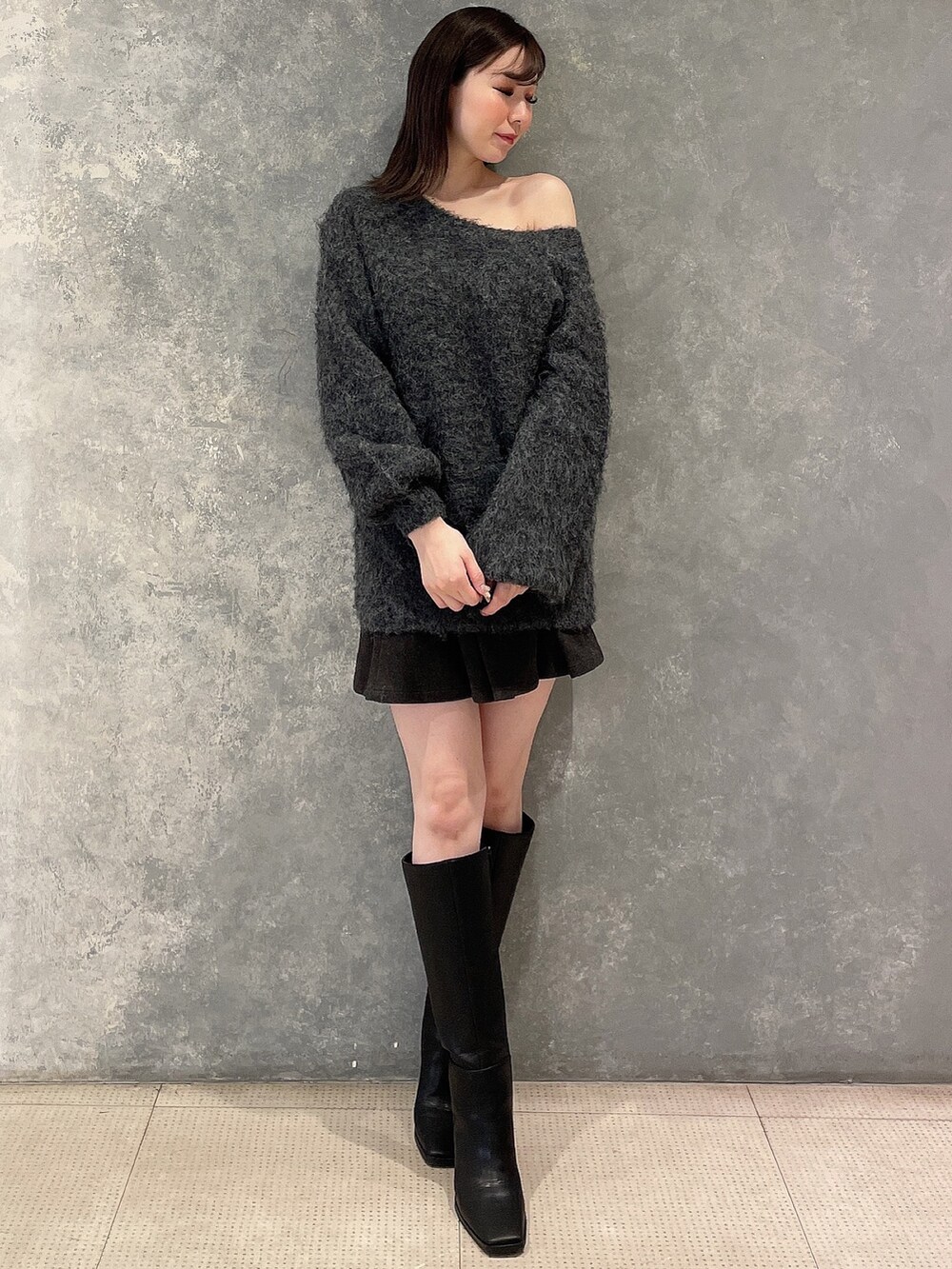 グレー系のワンピース、グレー系のスカート、ブラック系のブーツを着用したレディースの秋コーディネートの4枚目の写真