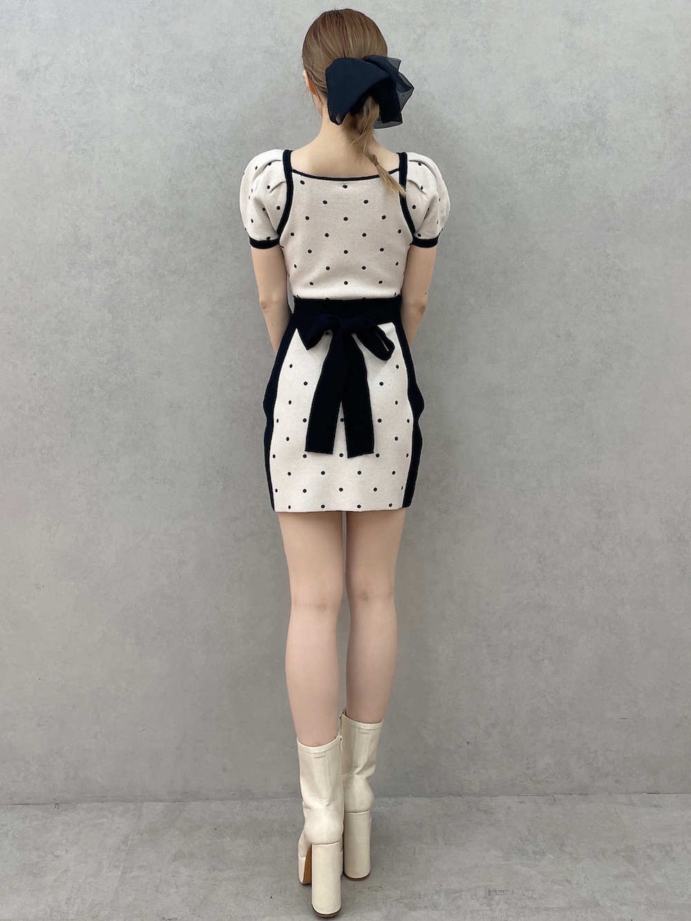 ブラック系のワンピース、ホワイト系のブーツ、ブラック系のバレッタ/ヘアクリップを着用したレディースの春コーディネートの4枚目の写真