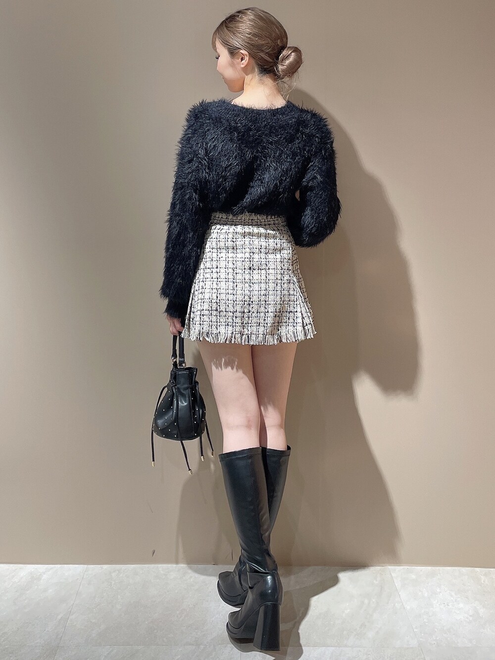 ブラック系のハンドバッグ、ブラック系のカーディガン/ボレロ、ホワイト系のスカートを着用したレディースの秋コーディネートの4枚目の写真